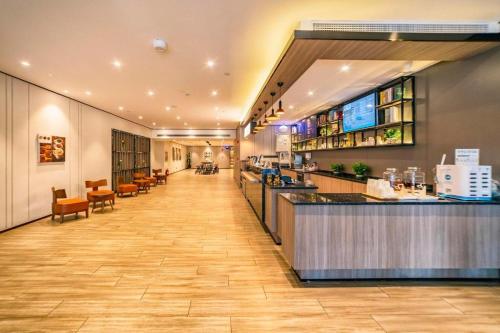 青岛Hanting Hotel Qingdao Xianggang Zhong Road Aofan Center的餐厅设有长长的走廊和酒吧