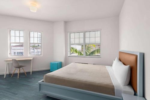 迈阿密海滩The Variety by LuxUrban的卧室配有一张床、一张书桌和窗户。