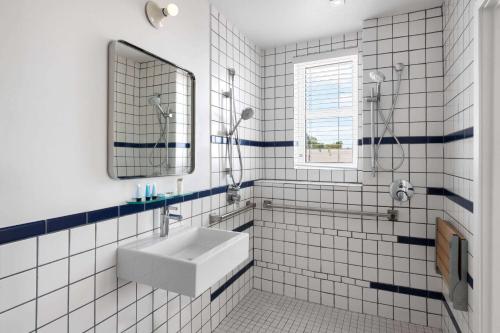 迈阿密海滩The Variety by LuxUrban的白色瓷砖浴室设有水槽和镜子