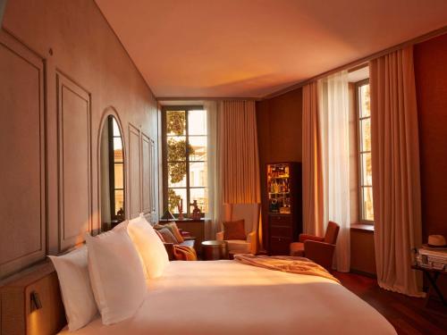 波尔多Mondrian Bordeaux Les Carmes的卧室设有一张带窗户的白色大床