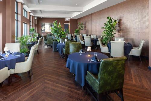 绿湾Legacy Hotel, Trademark Collection by Wyndham的用餐室配有蓝色的桌子和绿色的椅子