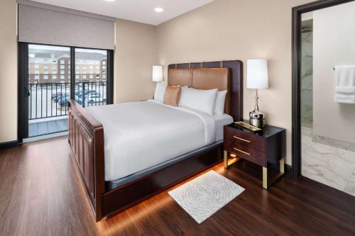 绿湾Legacy Hotel, Trademark Collection by Wyndham的一间带大床的卧室和一个阳台