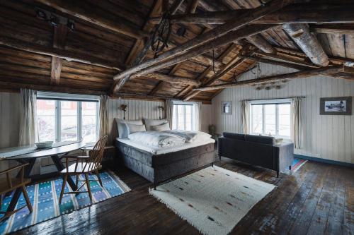 雷讷Reine Rorbuer - by Classic Norway Hotels的一间卧室配有一张床、一张桌子和一张桌子