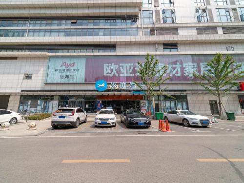 江岸Hanting Hotel Wuhan Shumin Zhijia的停车场,停车场停在大楼前