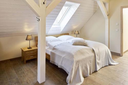 Rietz NeuendorfAlte Scheune的一间卧室配有一张带白色床单和天窗的床。