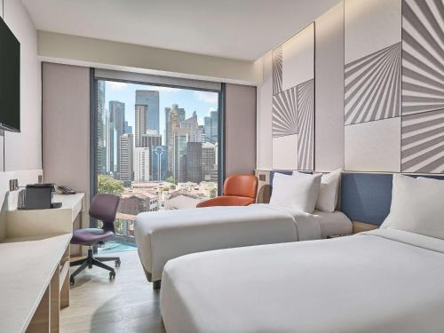 新加坡Mercure ICON Singapore City Centre的酒店客房设有两张床和窗户。