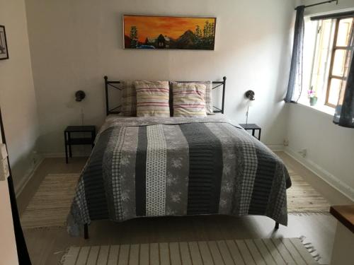 斯图伯克宾Stubbekøbingrooms的一间卧室配有一张黑色和灰色的棉被的床