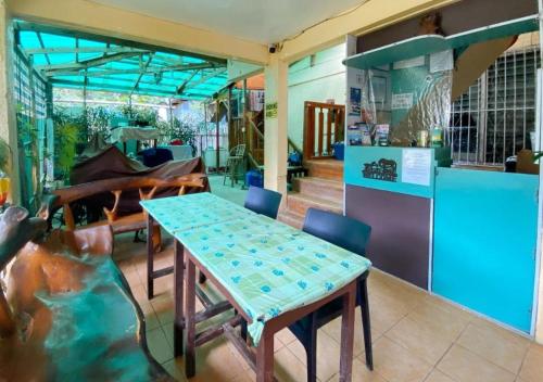 Santa MonicaRedDoorz Hostel @ Bunakidz Lodge El Nido Palawan的带厨房的客房内的桌椅