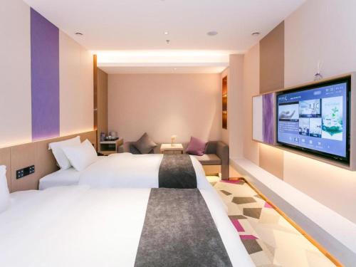 惠州Lavande Hotel Huizhou World Trade Center的一间酒店客房,配有一张大床和一台平面电视
