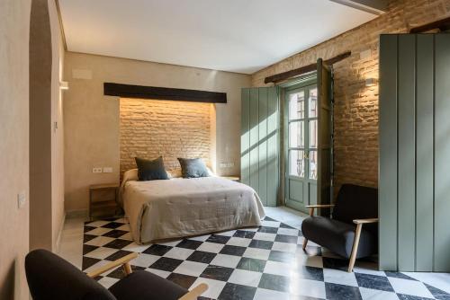 塞维利亚Luxury Palace Sevilla的一间卧室配有一张床,铺有一个 ⁇ 板地板