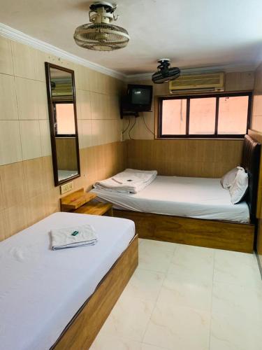 孟买Hotel Sagar Residency的带2扇窗户的小客房内的2张床