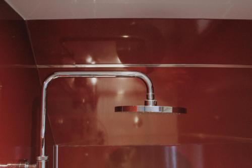 卡博斯特One Bedroom Apartment - Carbost - Skye的浴室水槽和红色墙壁上的水龙头