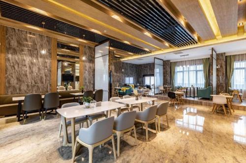 长沙Atour Hotel Changsha Wanbao Avenue的一间在房间内配有桌椅的餐厅