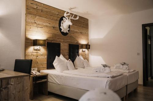 Laubach瓦尔德酒店的一间卧室设有一张带木墙的大床