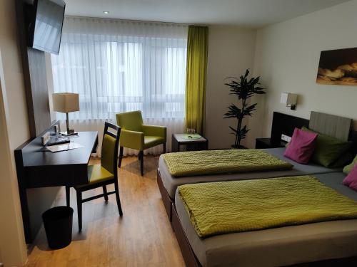 腓特烈港Hotel Gästehaus Stock Zimmer Brotkörble的酒店客房配有两张床和一张书桌