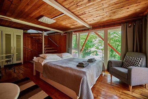 KismarosOlive Tree Forest Cabin Original的一间卧室配有一张床和一把椅子
