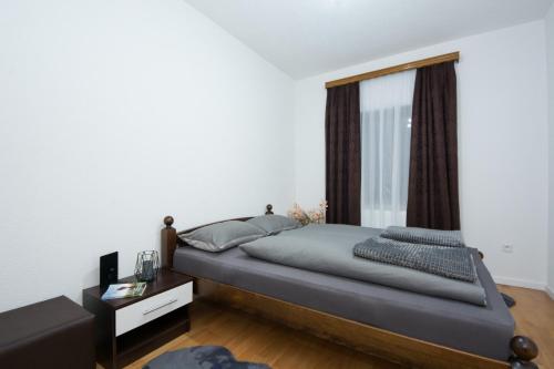 Sanski mostGOLD Apartman的一间卧室设有一张大床和一个窗户。