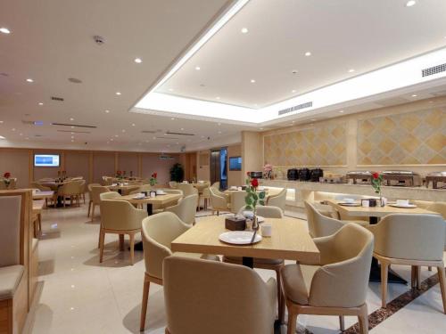 兴仁Vienna Hotel Guizhou Xingren的一间在房间内配有桌椅的餐厅