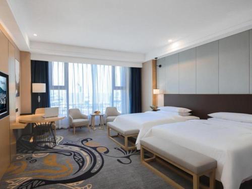 鄂尔多斯Venus Royal Hotel Ordos Yijinhuoluo Banner Olympic的酒店客房设有两张床和电视。