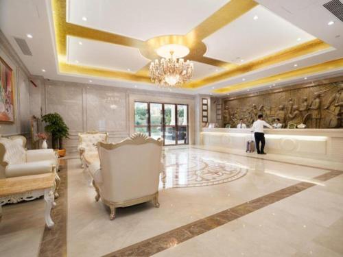 惠东Vienna Hotel Guangdong Huidong Exhibition Center的站在带吊扇的客厅的人