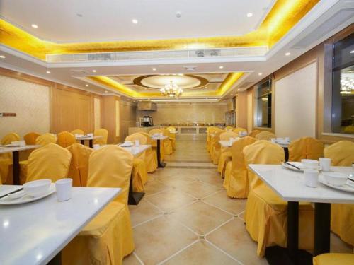 惠东Vienna Hotel Guangdong Huidong Exhibition Center的用餐室配有桌子和黄色布布椅