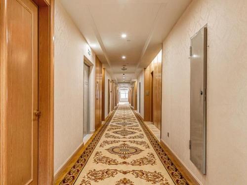 惠东Vienna Hotel Guangdong Huidong Exhibition Center的地板上铺着地毯的空走廊