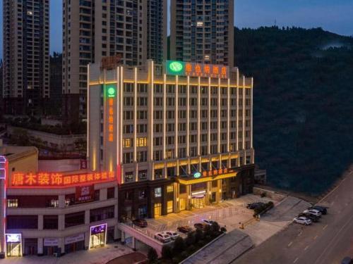 丰都Vienna Hotel Chongqing Fengdu的上面有绿色标志的建筑