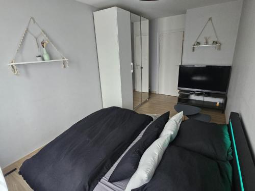 安纳马斯Chambre d'hôte - hypercentre的一间卧室配有一张床和一台平面电视