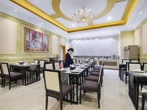 喀什Vienna Hotel Xinjiang Kashgar 2nd Ring Road Food Street的站在餐厅桌子上的女人