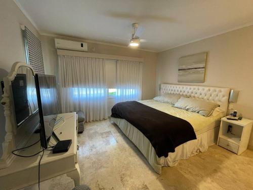 GualeguaychúCasa Quinta Moderna - Country Golf的一间卧室配有一张床和一台平面电视