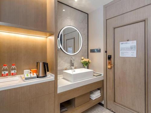 HuantuoVienna Hotel Tianjin Jinzhong Street的一间带水槽和镜子的浴室
