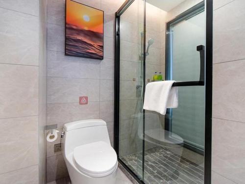HuantuoVienna Hotel Tianjin Jinzhong Street的一间带卫生间和玻璃淋浴间的浴室