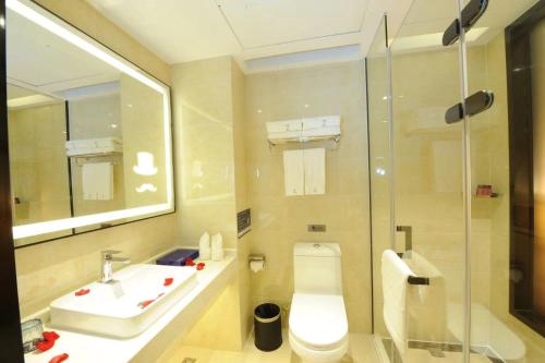 广州潮漫酒店（广州火车站三元里地铁站店）的浴室配有卫生间、盥洗盆和淋浴。