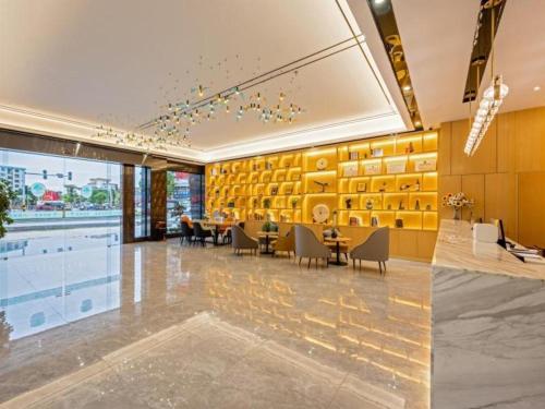 BaigaonongchangGreen Tree Inn Zhuhai International Airport Huafa Shangdu的大堂设有桌椅和游泳池