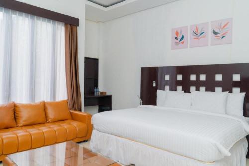 SaroakoHotel Mireya Sorowako的一间卧室配有一张大床和一张沙发