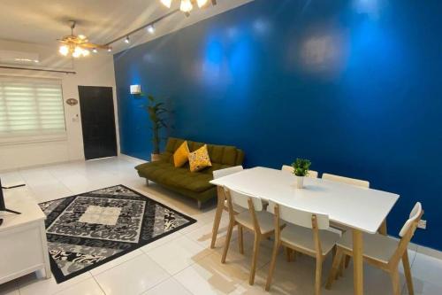 斯里曼绒R&R Manjung Guest House at Pangsapuri Samudera的客厅配有白色桌子和蓝色的墙壁