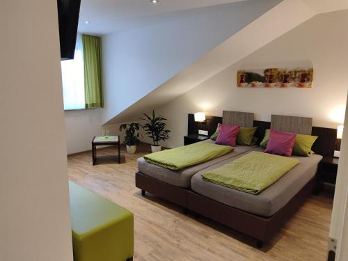腓特烈港Hotel Gästehaus Stock Zimmer Teekännle的一间卧室配有带粉色和绿色枕头的床