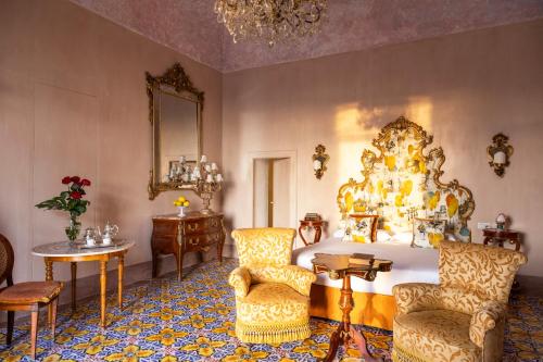 托雷德尔格雷科Villa De Cillis Carafa的一间卧室配有一张大床、椅子和镜子