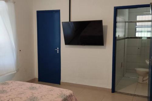 雷森迪Sede dos supiros的一间卧室设有一扇蓝色门,配有平面电视