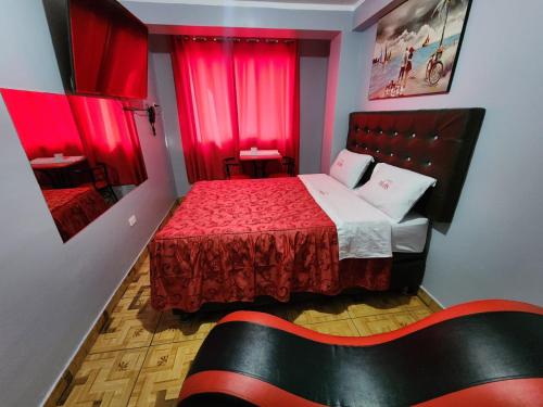 利马hostal paris的小房间,配有红色窗帘的床