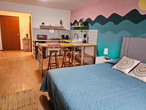 利马Alojamiento San Francisco Espaciosos y lindos mini apartamentos的一间卧室配有一张床,厨房配有柜台