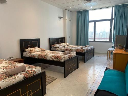 阿布扎比J & F Homestay - Abu Dhabi的带三张床和窗户的客房