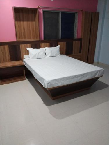 MadhubaniHotel Jyoti的一间卧室配有一张带白色床单的床和一扇窗户。