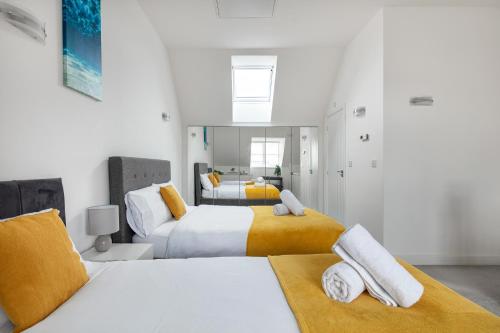 卢顿NEW Luton 3 Bedroom house, Contractors & families, Sleeps 7 with Free Parking & WIFI的一间卧室设有两张黄色和白色的床