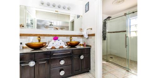 普罗维登西亚莱斯岛NEW Waterside Home Whirlpool Spa Tub Smart TV的一间带两个盥洗盆和淋浴的浴室