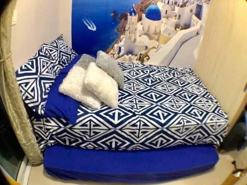 马尼拉The Grass Residences的一张带蓝色和白色枕头的床