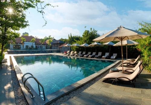 宁平Memorina Ninh Binh Resort的一个带躺椅和遮阳伞的游泳池