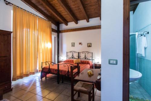 阿尔布斯Turismo Rurale La Miniera Fiorita的一间卧室配有一张床、一张桌子和一个浴缸