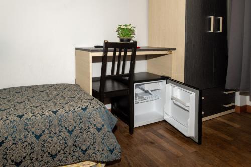 米兰乔亚别墅酒店的配有一张桌子和一张椅子的床边的房间