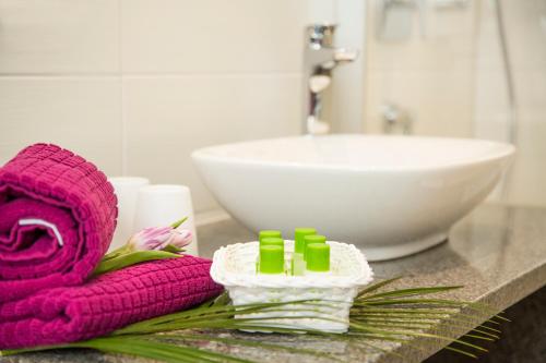 腓特烈港Hotel Gästehaus Stock Zimmer Schokotöpfle的浴室柜台配有粉红色毛巾和水槽